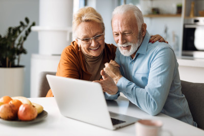 un couple à la retraite regarde un ordinateur