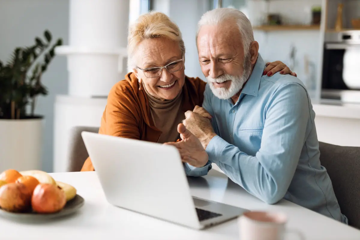 un couple à la retraite regarde un ordinateur