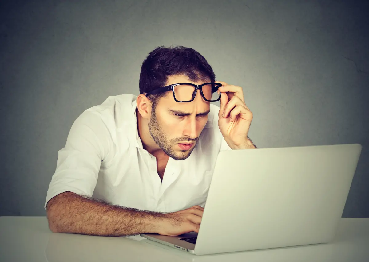 Homme avec des lunettes regarde son ordinateur