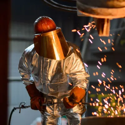 Un métallurgiste lors du coulage du métal d'un four à coupole