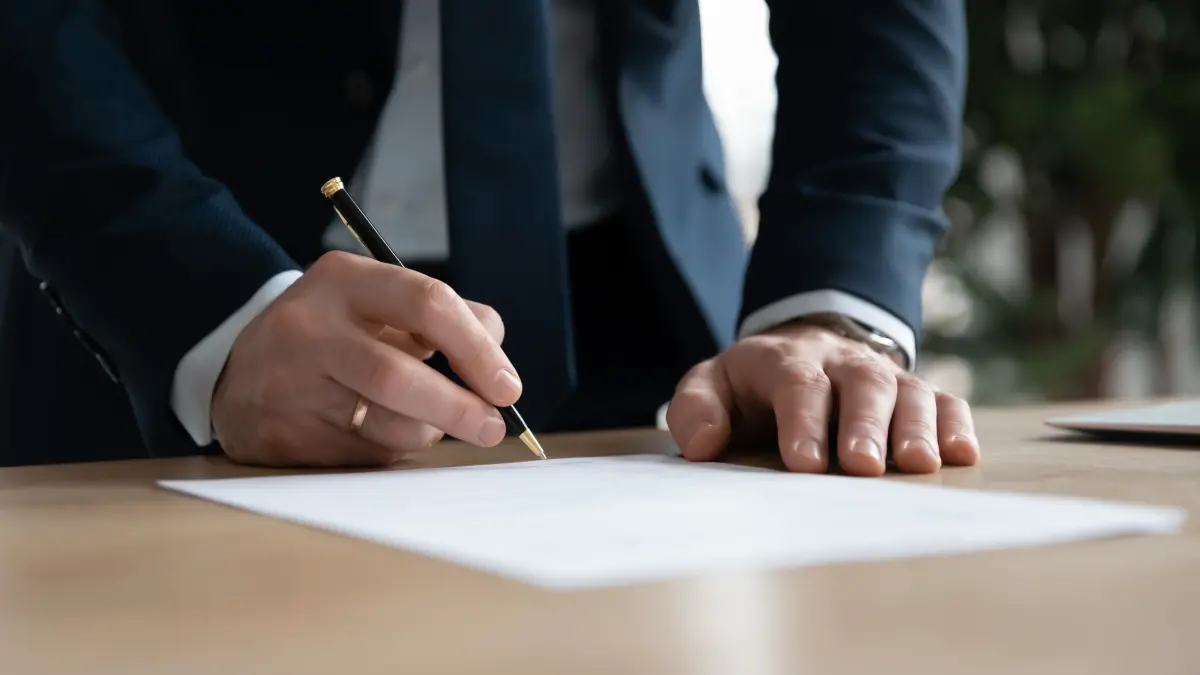 homme signe un papier