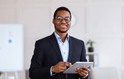 Jeune homme souriant avec une tablette à la main