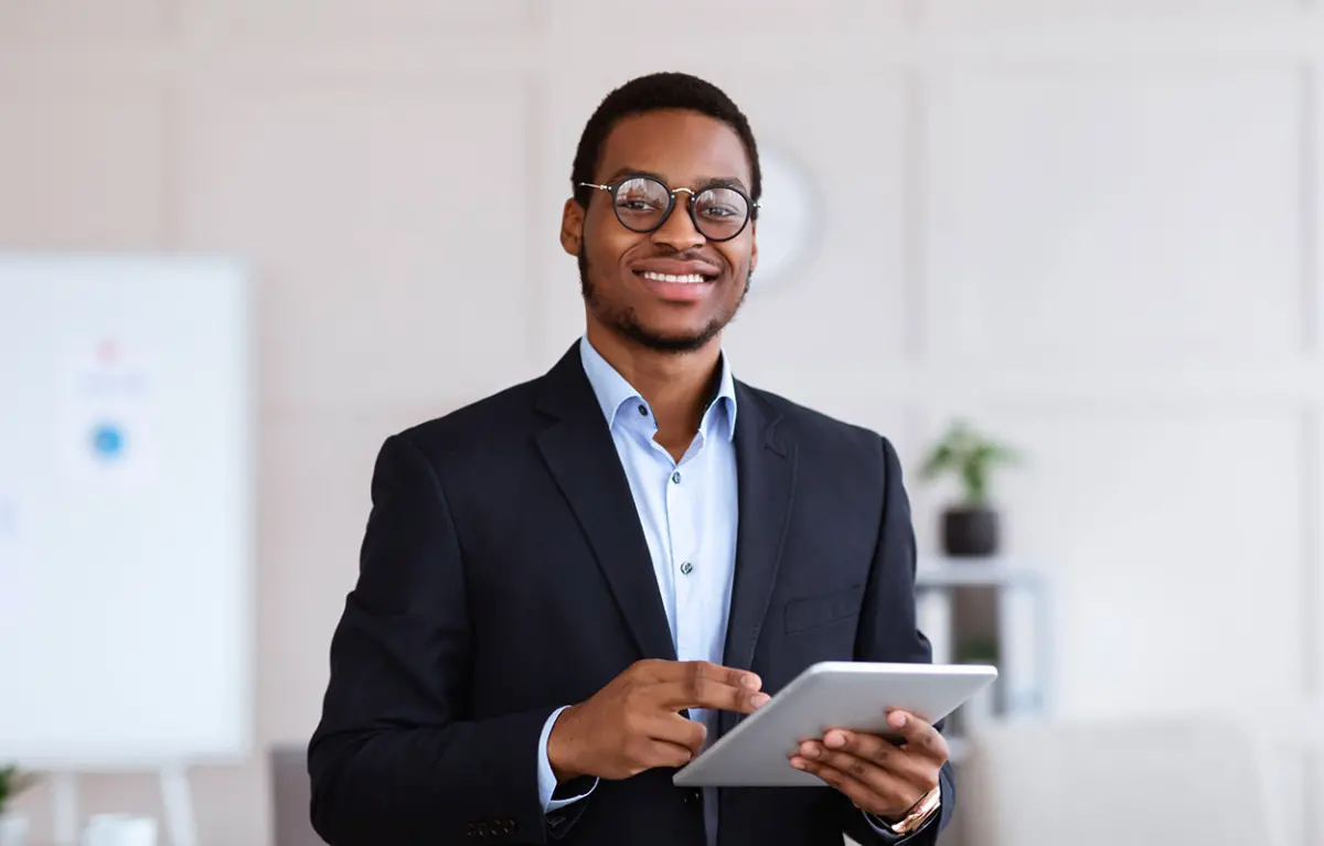 Jeune homme souriant avec une tablette à la main