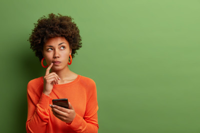 femme qui se pose des questions avec une calculatrice