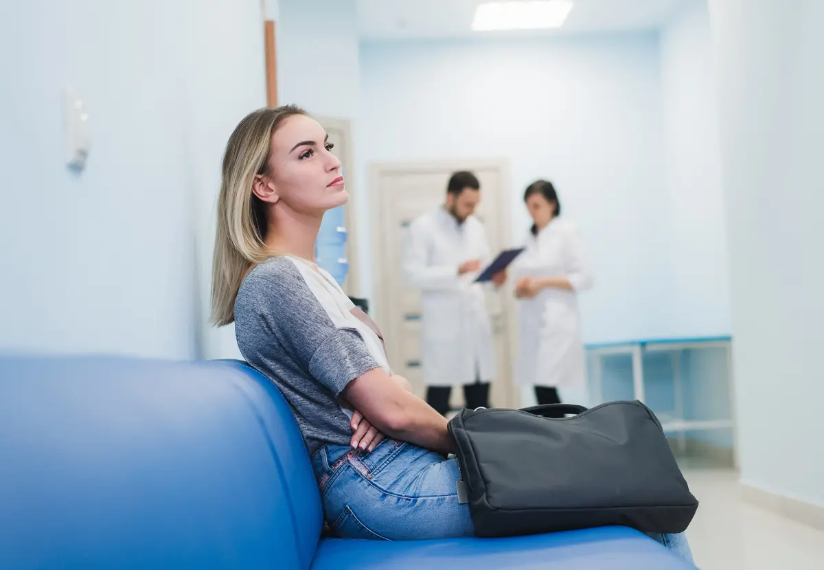 Femme assise sur un banc dans une salle d'attente à l'hôpital