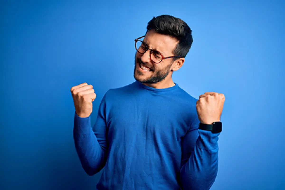 Homme avec un pull bleu qui est heureux