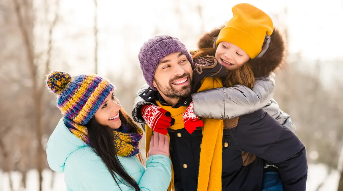 Famille avec blouson et bonnet se promène dehors pendant l'hiver