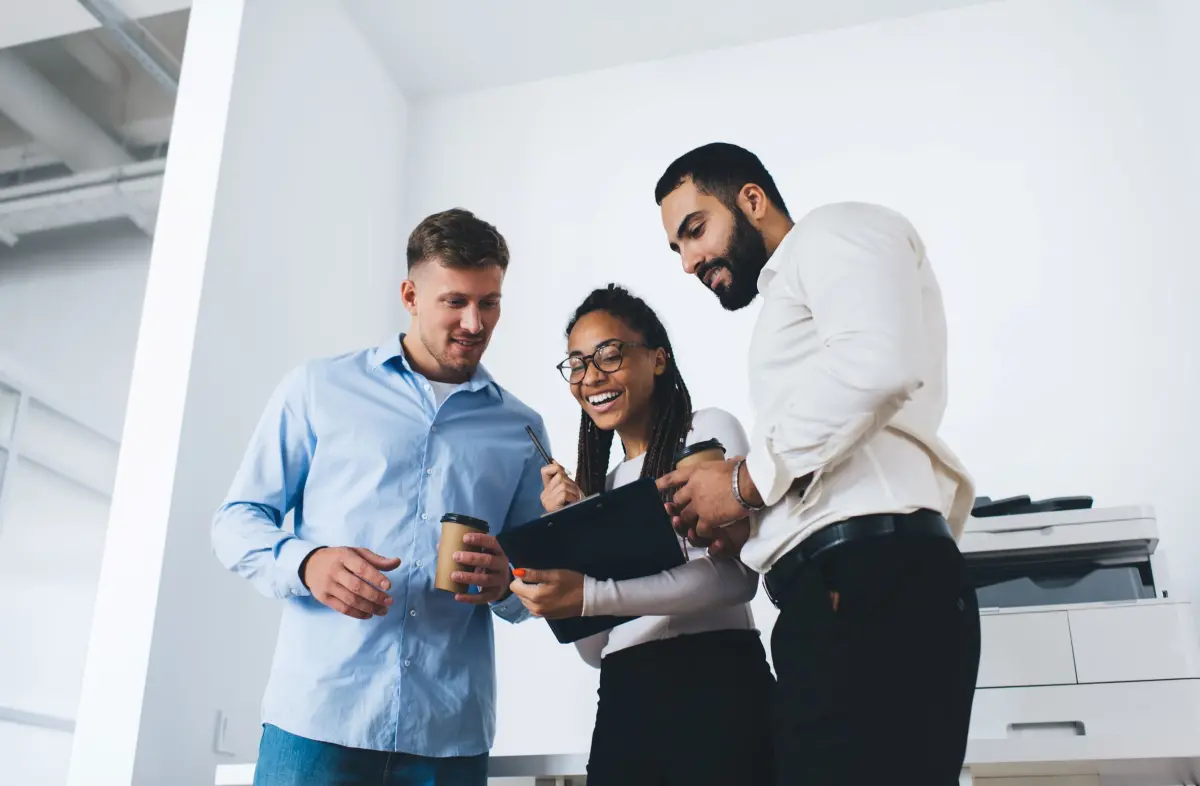Deux hommes et une femme content regardent un porte-bloc