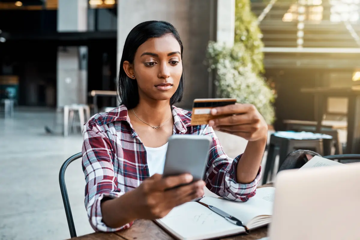 jeune femme payant en ligne avec sa carte bancaire