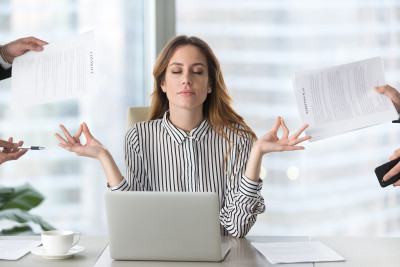 Jeune femme au bureau surmenée faisant du yoga