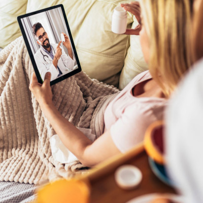 Jeune femme malade ayant une téléconsultation médicale à la maison