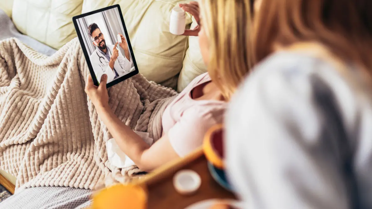 Jeune femme malade ayant une téléconsultation médicale à la maison