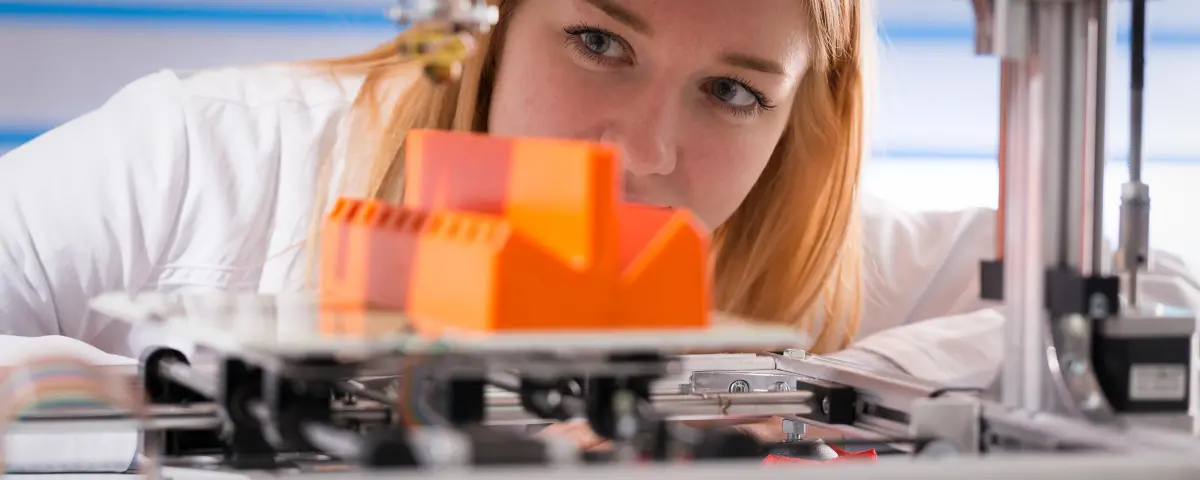 femme regarde la production d'un élément en plastique