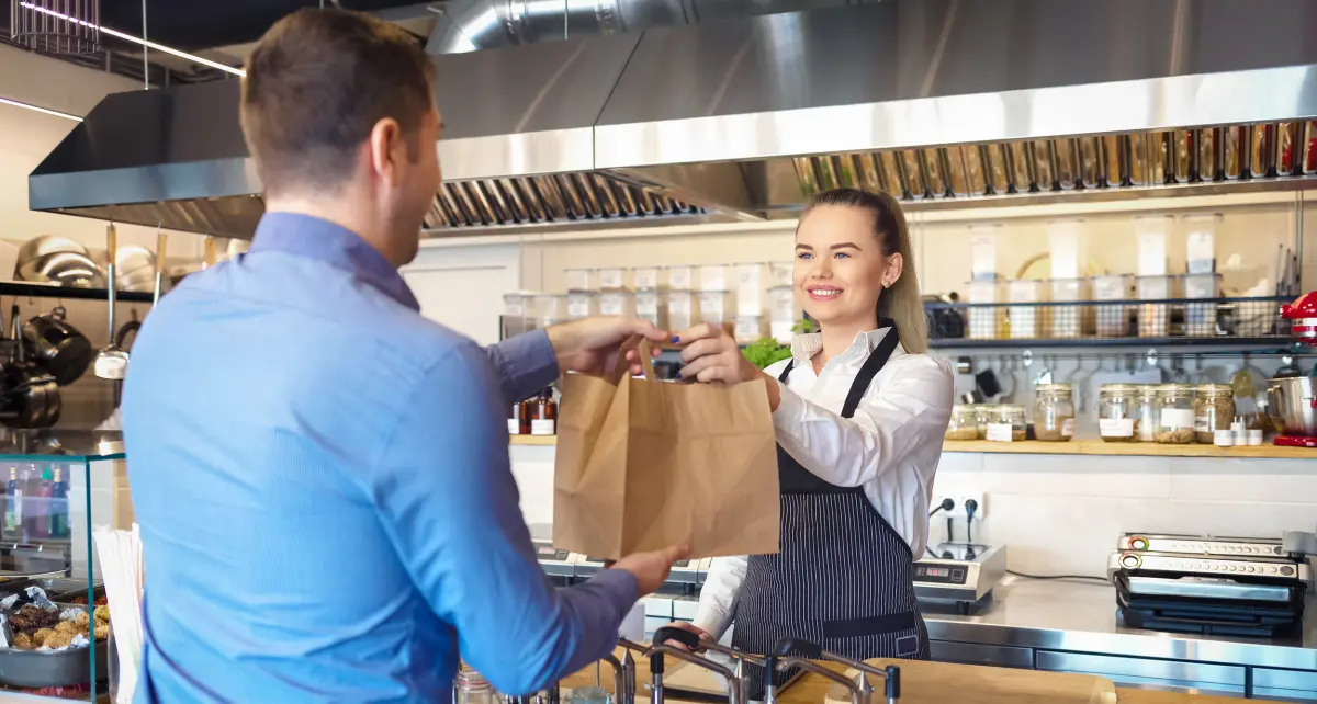 employée de restauration rapide remet sa commande au client