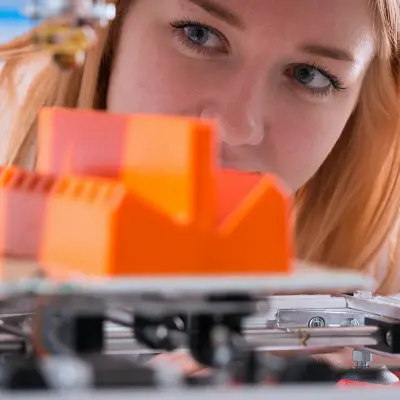 femme regarde la production d'un élément en plastique