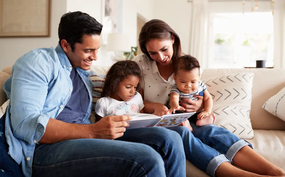 famille avec de jeunes enfants qui regarde un livre