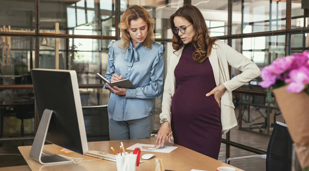 Femme enceinte avec sa collègue dans un bureau
