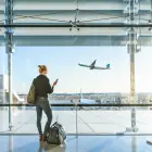 Jeune femme regardant son téléphone attend dans un aéroport